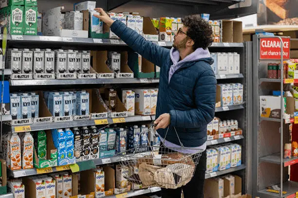Homem pegando um produto na prateleira de cima